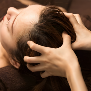 Kỹ thuật viên đang thực hiện massage đầu thư giãn trong liệu trình gội đầu dưỡng sinh tại Aman Spa.